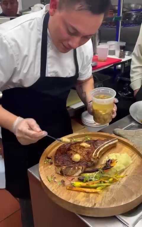 Chef finishing a bone-in rib steak