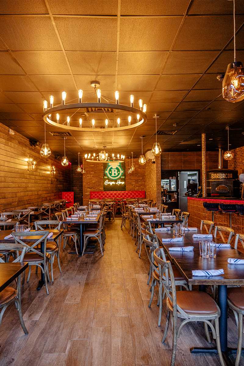 Barbacoa dining room with ring chandeliers and red banquette
