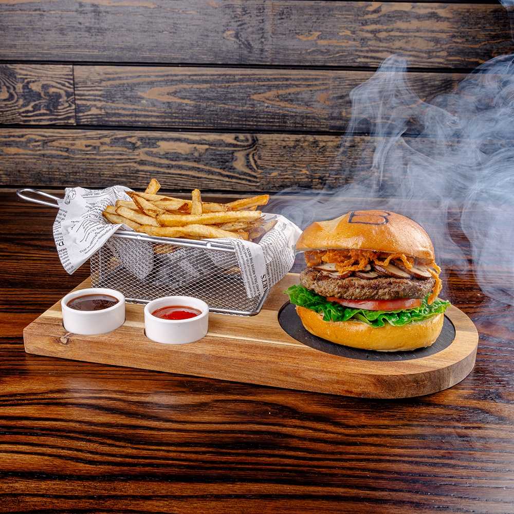 The cloche lifted, smoke rising from the burger